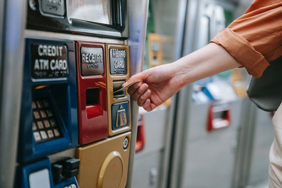  Mit einer Kreditkarte an einem Geldautomaten Bargeld abheben